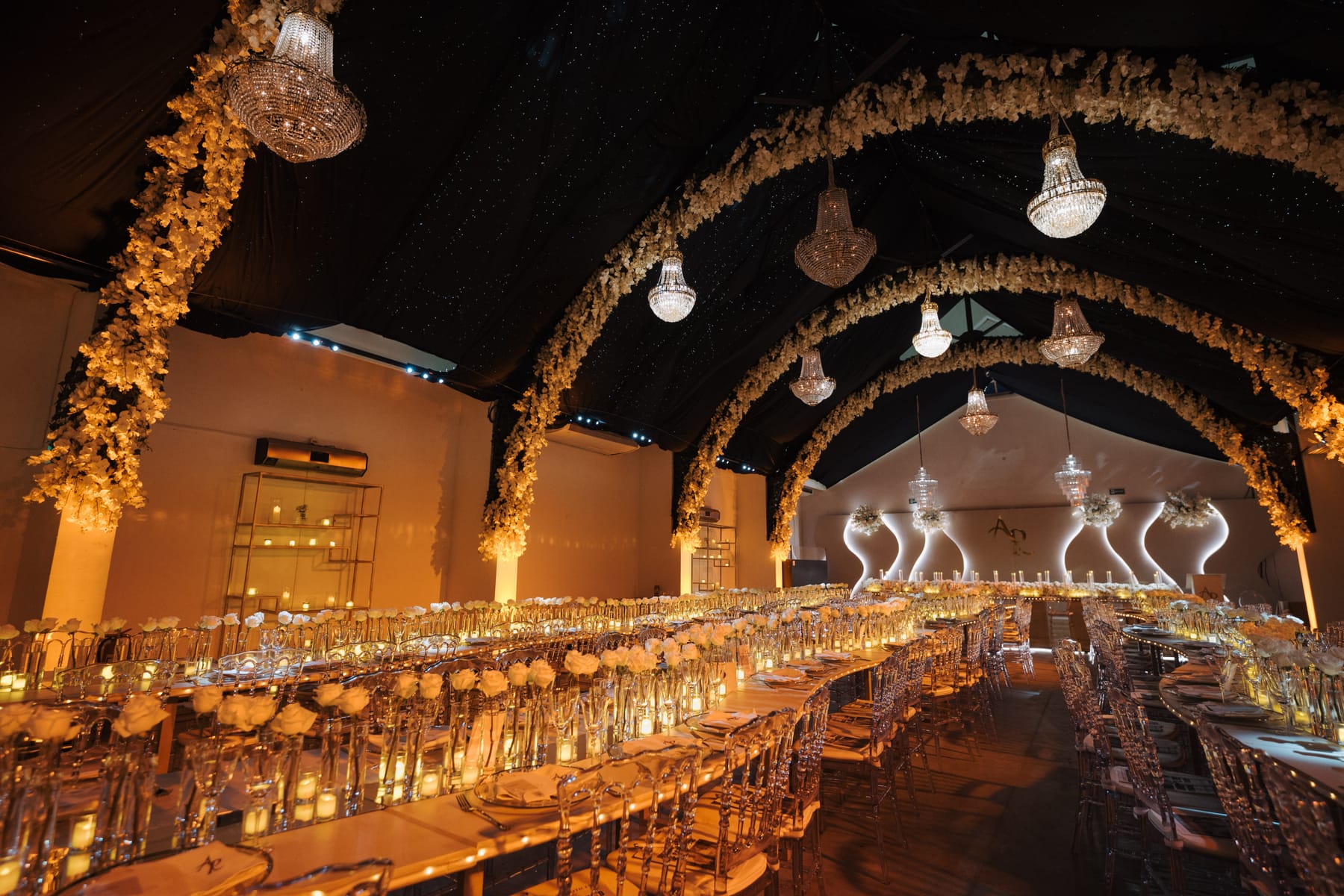 Boda R&A — salón dorado con arcos florales, ambientado por Cecilia Eriksson Eventos